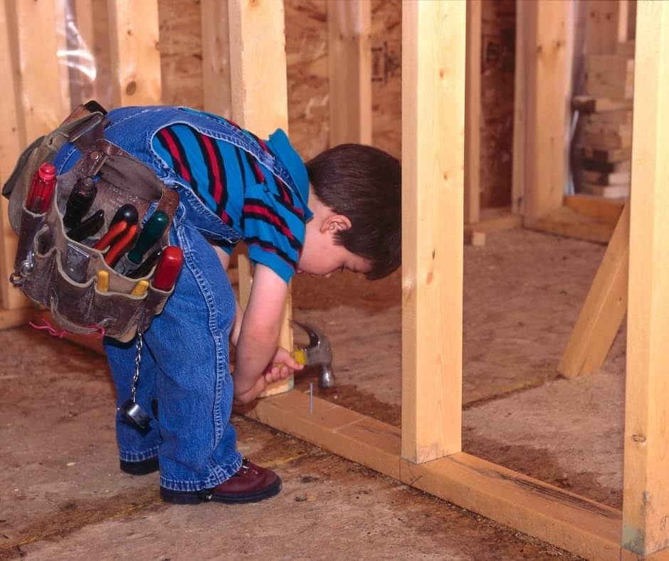 Little boy with hammer in a house under construction business consulting services for contractors and tradesmen