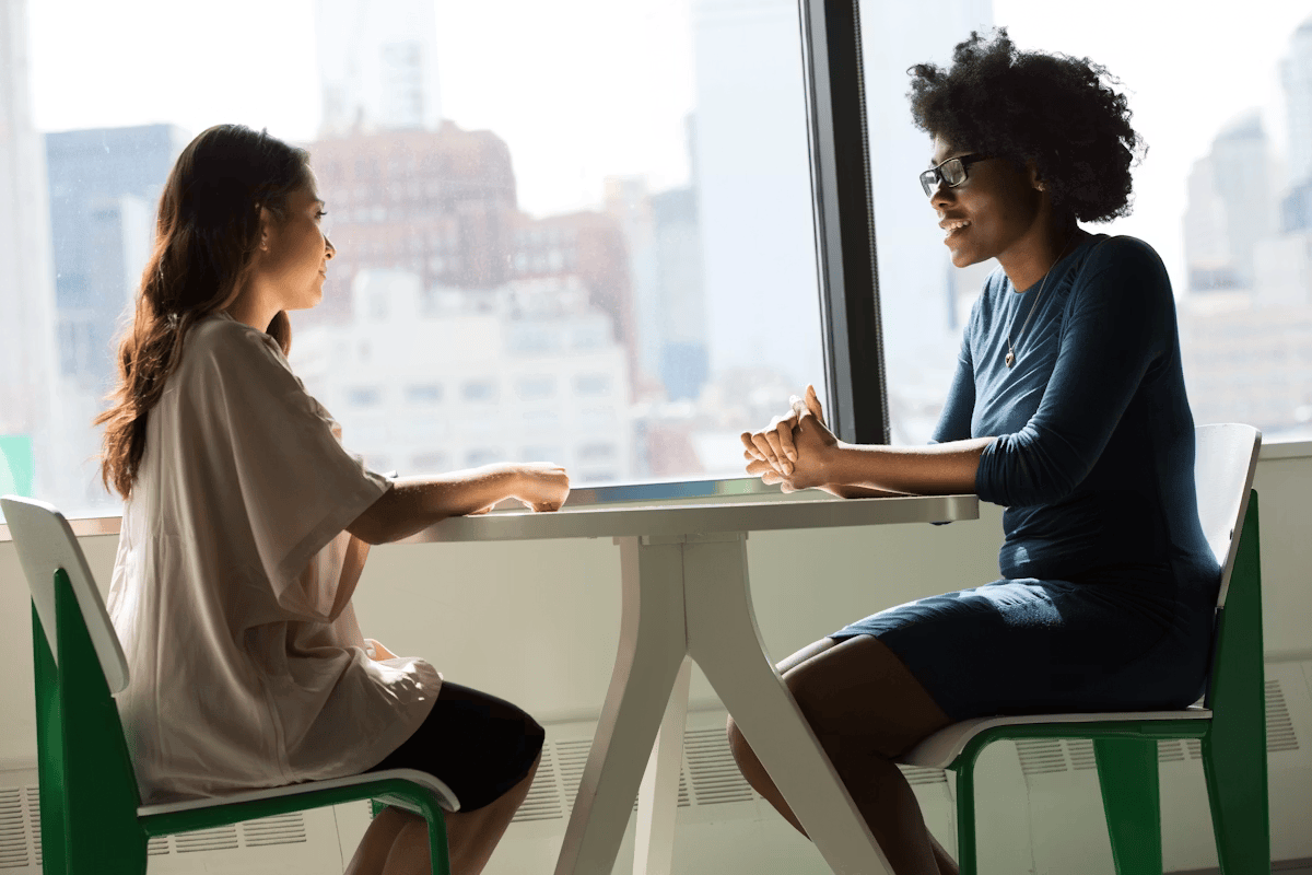 Two women having a consultation at a table with a city view
